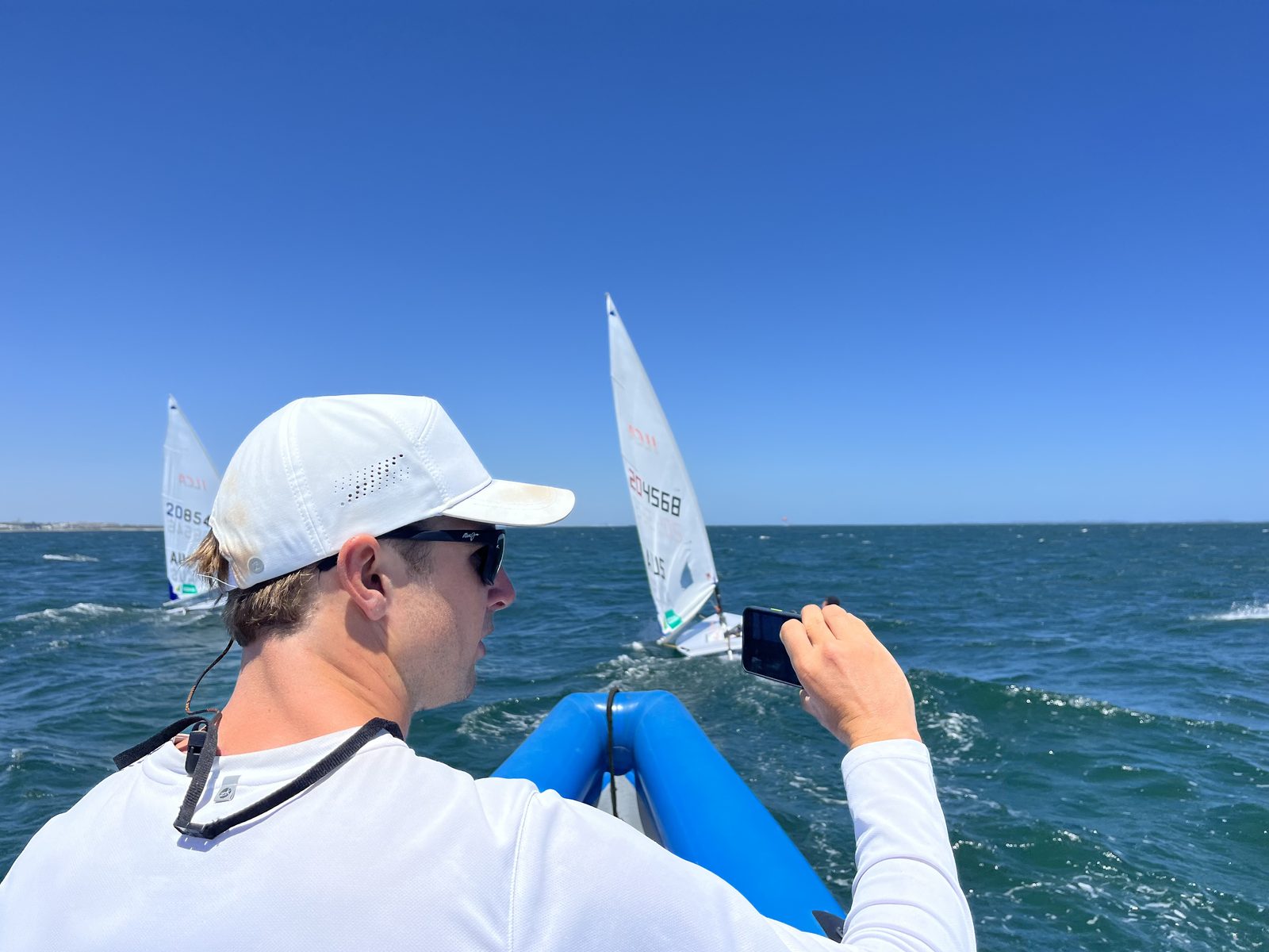 An Australian sailing coach filming athletes from a support boat